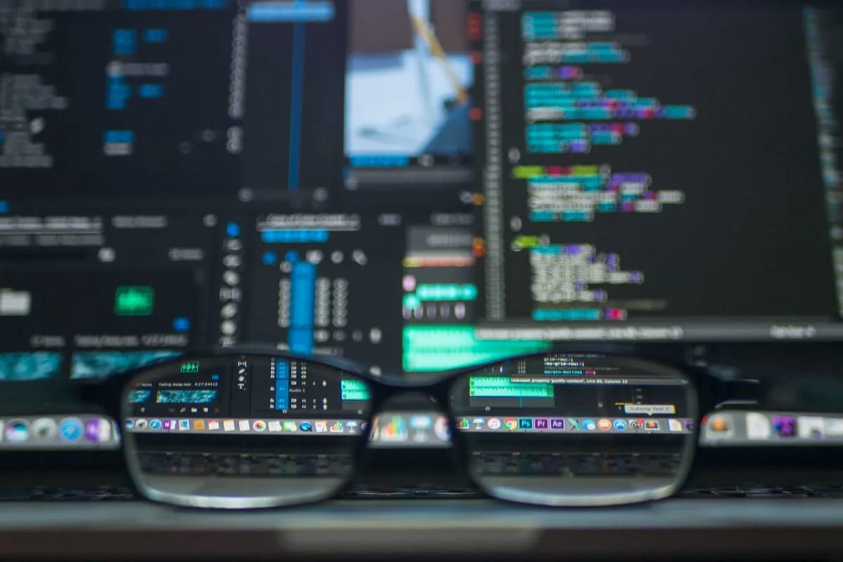 Developer reviewing code on a laptop screen representing the PR review gate where workflow configuration changes must be caught before reaching the main branch